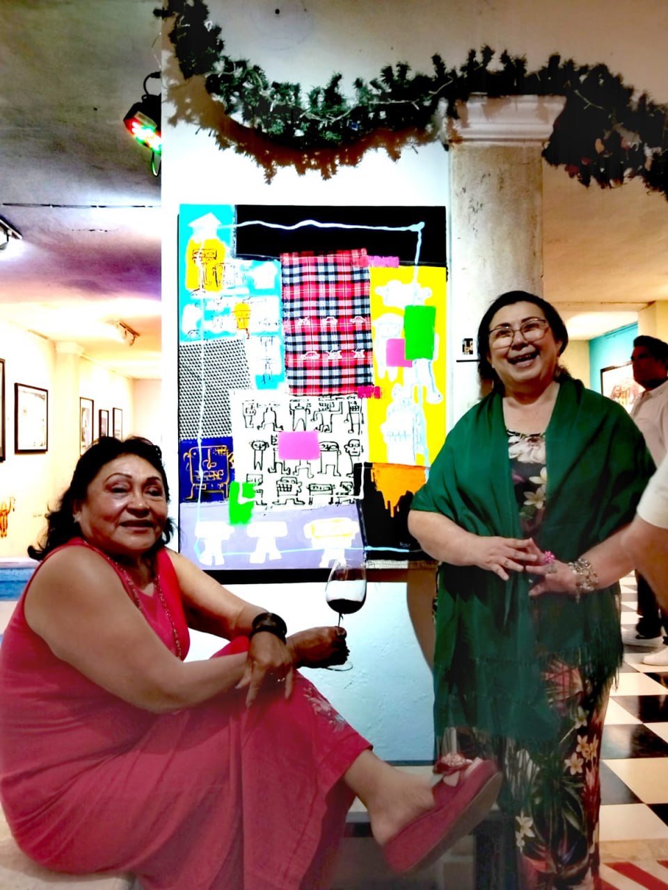 Asistentes posan junto a una de las obras de la exposición